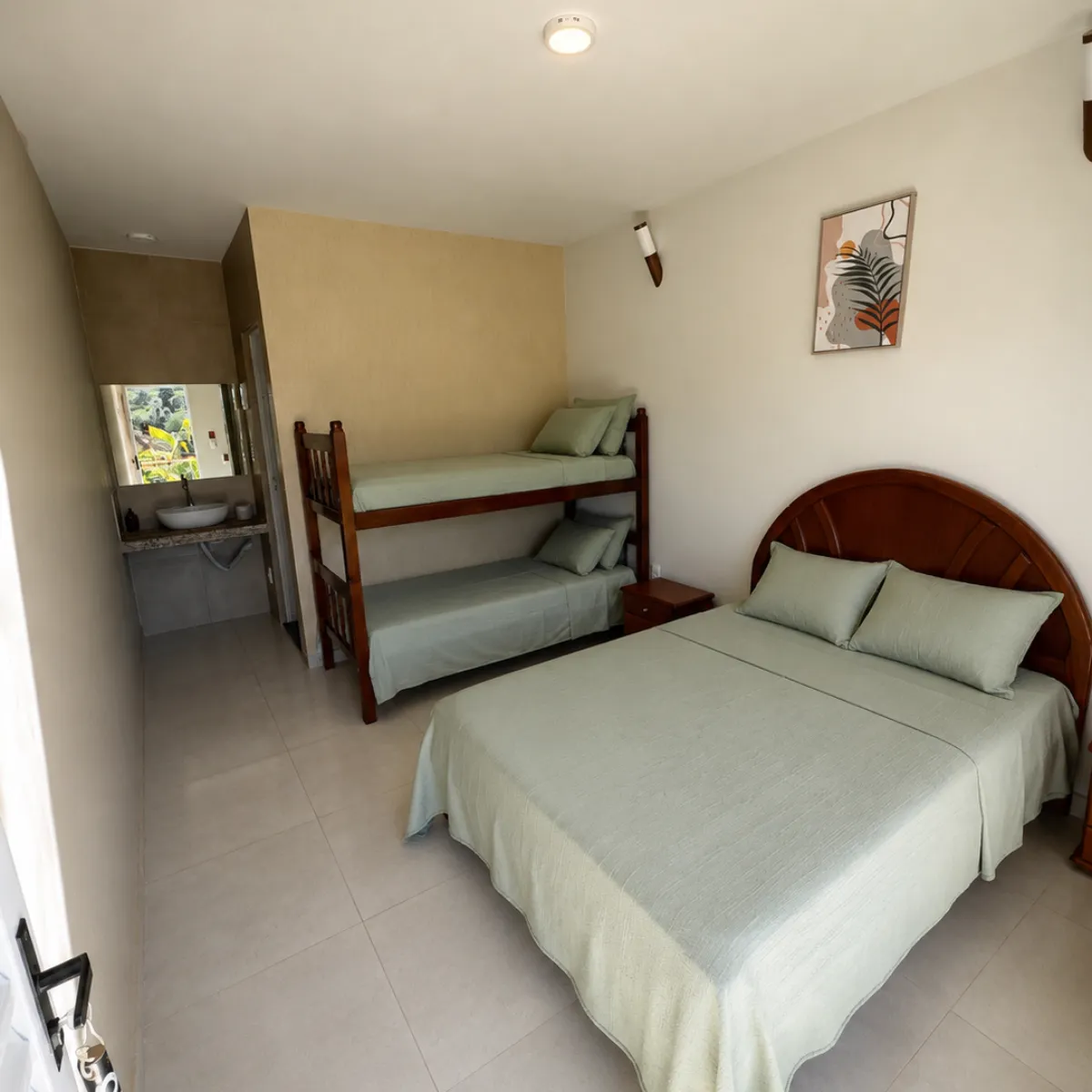 Suíte com cama de casal, beliche e banheiro privativo ao fundo